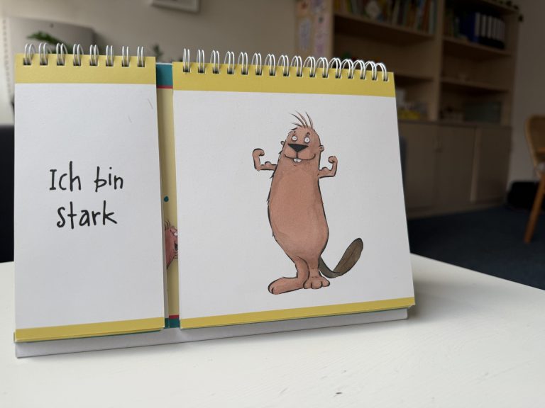 In einem Buch sind Seiten zum umblättern und zu sehen sind ein gezeichneter Bieber, der seinen Oberarm anspannt und daneben der Text: Ich bin stark